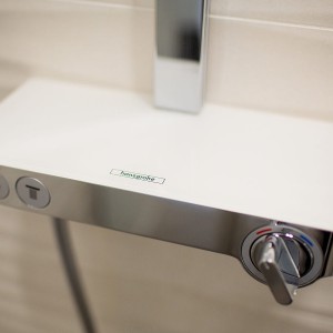 Detail vzorkové koupelny v koupelnovém studiu Gremis - moderní ovládání sprchy sloužící i jako odkládací prostor
