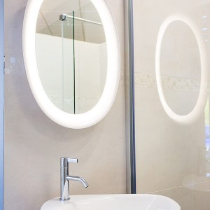 Detail vzorkové koupelny v koupelnovém studiu Gremis - umývací stěna, moderní oválné zrcadlo