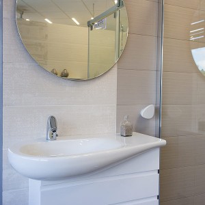 Detail vzorkové koupelny v koupelnovém studiu Gremis - umývací stěna s moderním umyvadlem a zrcadlem